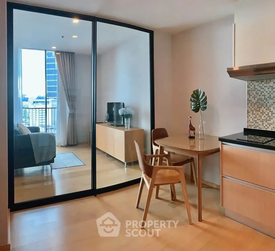 Modern open-plan kitchen and living room with city view, featuring sleek furniture and stylish decor.