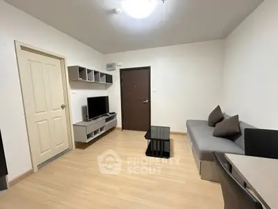 Modern living room with sleek furniture and wooden flooring in a cozy apartment.