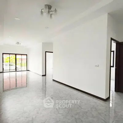 Spacious modern living room with marble flooring and large windows for natural light.