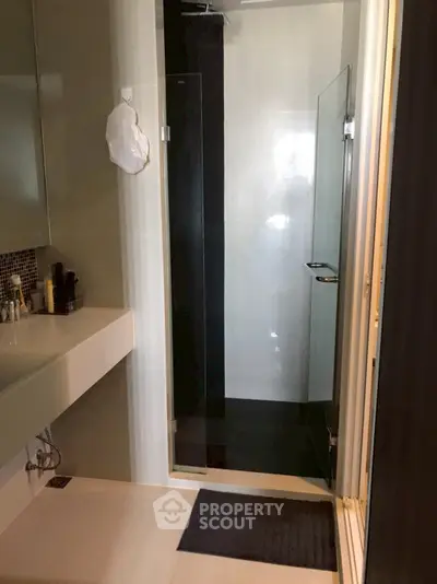 Modern bathroom with sleek shower and stylish sink area.