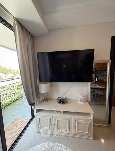 Stylish living room with large TV and balcony view, perfect for modern living.