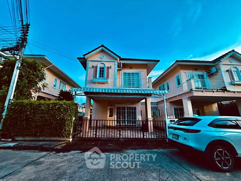 Charming two-story house with gated driveway and modern exterior design in a serene neighborhood.
