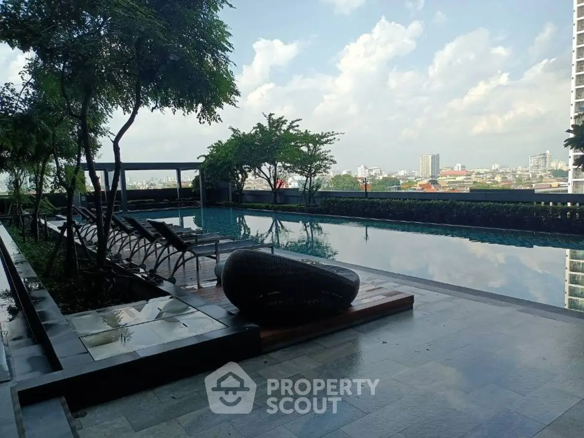 Luxurious rooftop pool with stunning city skyline view and modern lounge chairs.