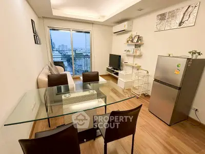 Modern living room with city view, glass dining table, and sleek appliances.