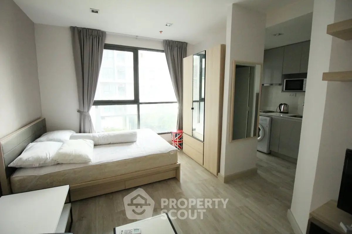 Modern studio apartment with natural light and compact kitchen area, ideal for urban living.