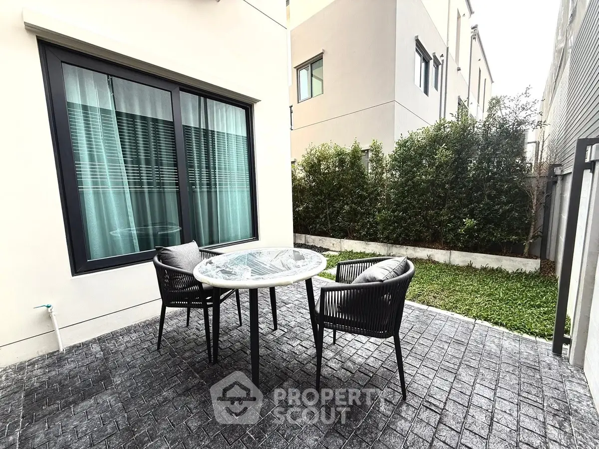 Charming outdoor patio with modern furniture and lush greenery, perfect for relaxation and entertaining.