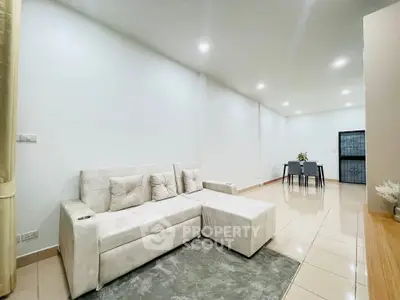 Spacious modern living room with elegant white sofa and dining area