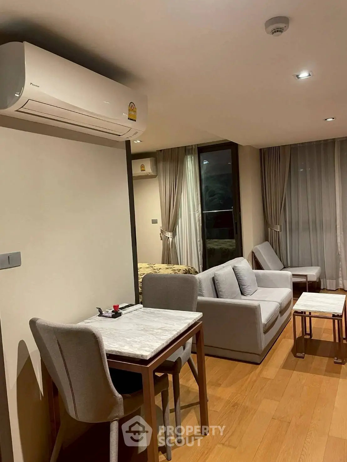 Modern living room with cozy seating and dining area, featuring elegant decor and natural lighting.