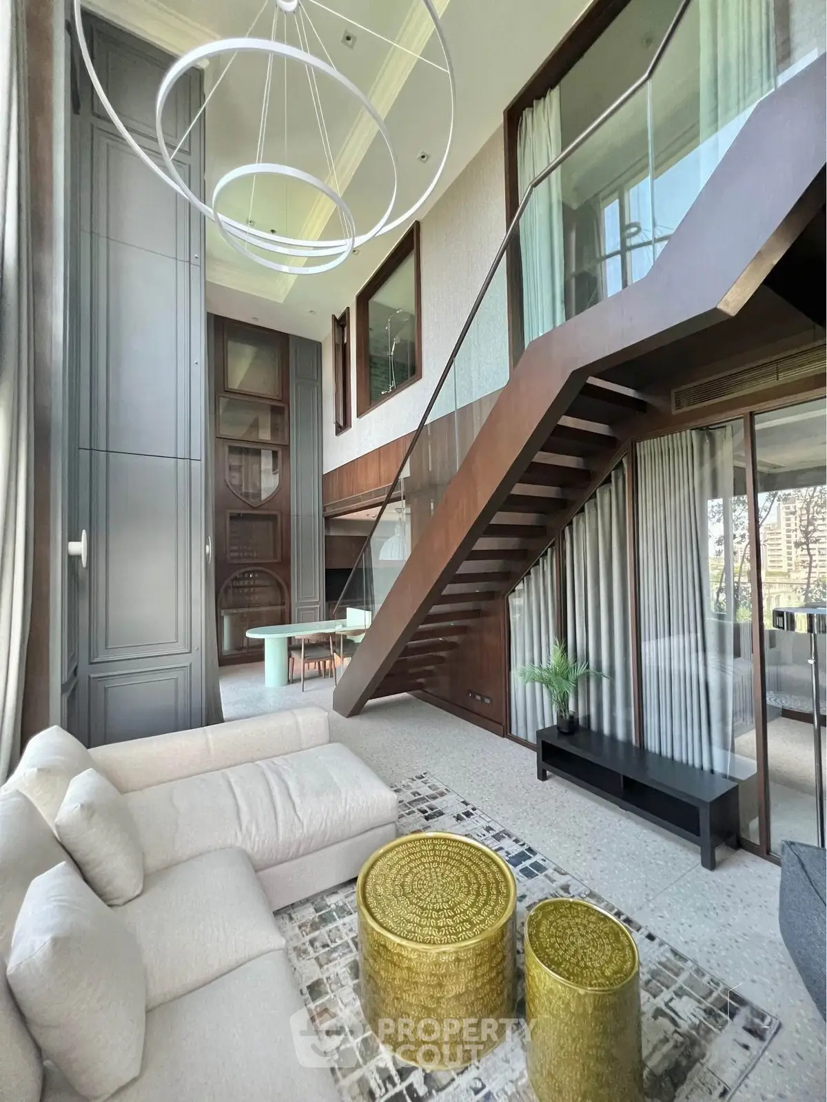 Luxurious modern living room with high ceilings and elegant staircase