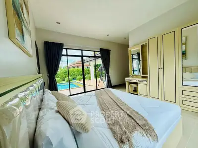 Spacious bedroom with pool view and modern furnishings
