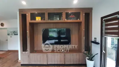 Modern living room with stylish wooden entertainment center and large TV