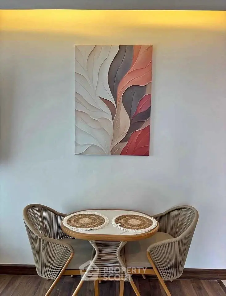 Stylish small dining area with modern chairs and abstract wall art, perfect for cozy meals.