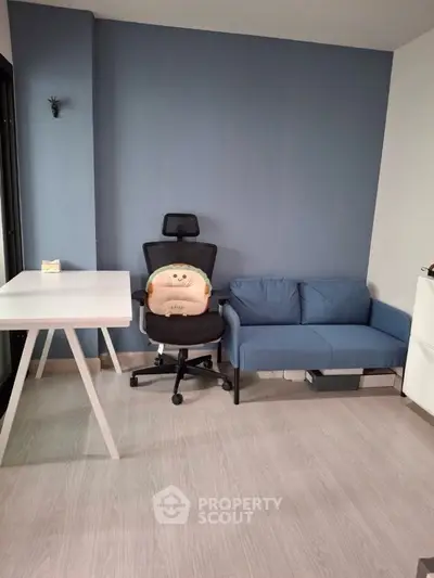 Modern study room with ergonomic chair and stylish blue sofa
