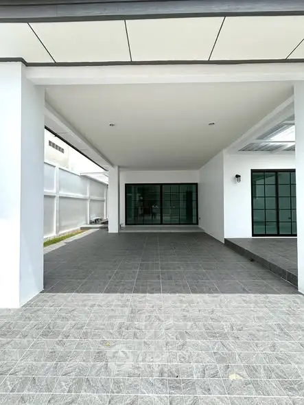 Spacious modern home entrance with sleek tiled flooring and large windows.