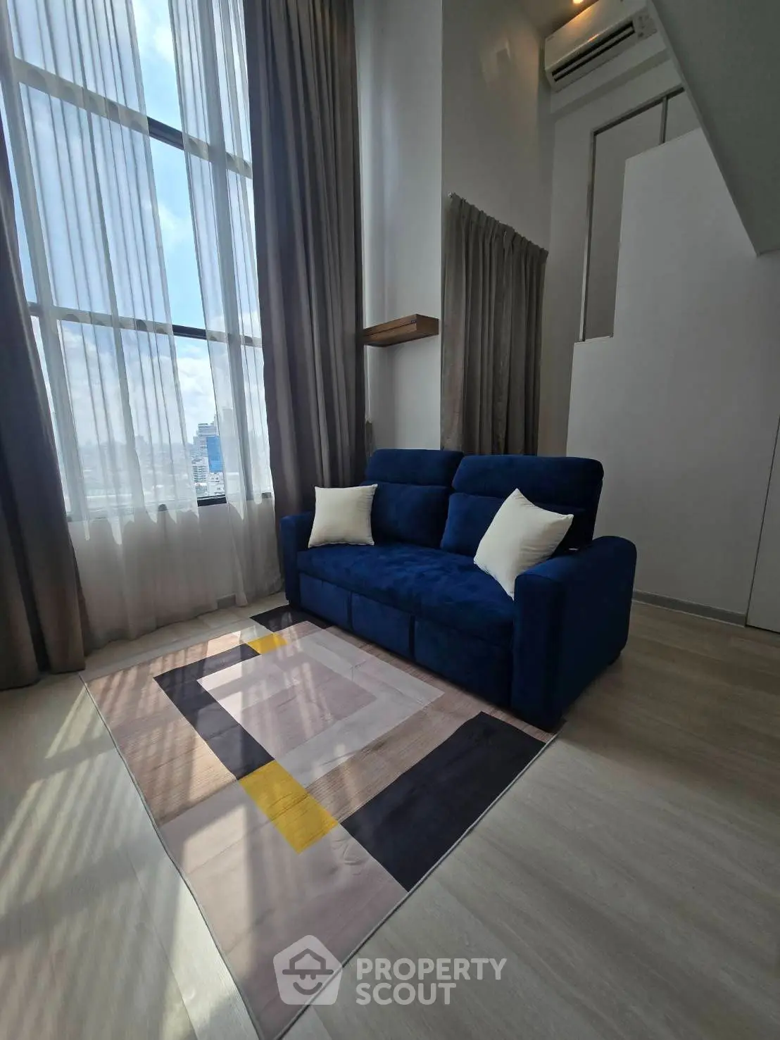 Stylish living room with high ceilings and modern blue sofa