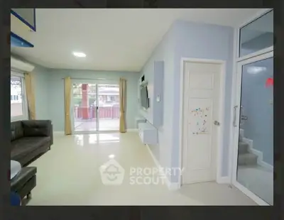 Spacious living room with modern decor and large windows leading to a balcony.