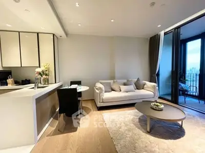 Modern living room with open kitchen and balcony view in luxury apartment.
