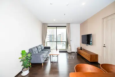 Modern living room with city view, stylish furniture, and natural light.