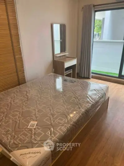 Modern bedroom with balcony access and stylish wooden flooring