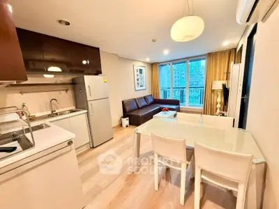 Modern open-layout living room with kitchen, dining area, and large windows in a stylish apartment.