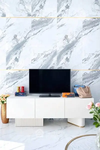 Luxurious living room with marble walls and modern TV stand, showcasing elegant interior design.