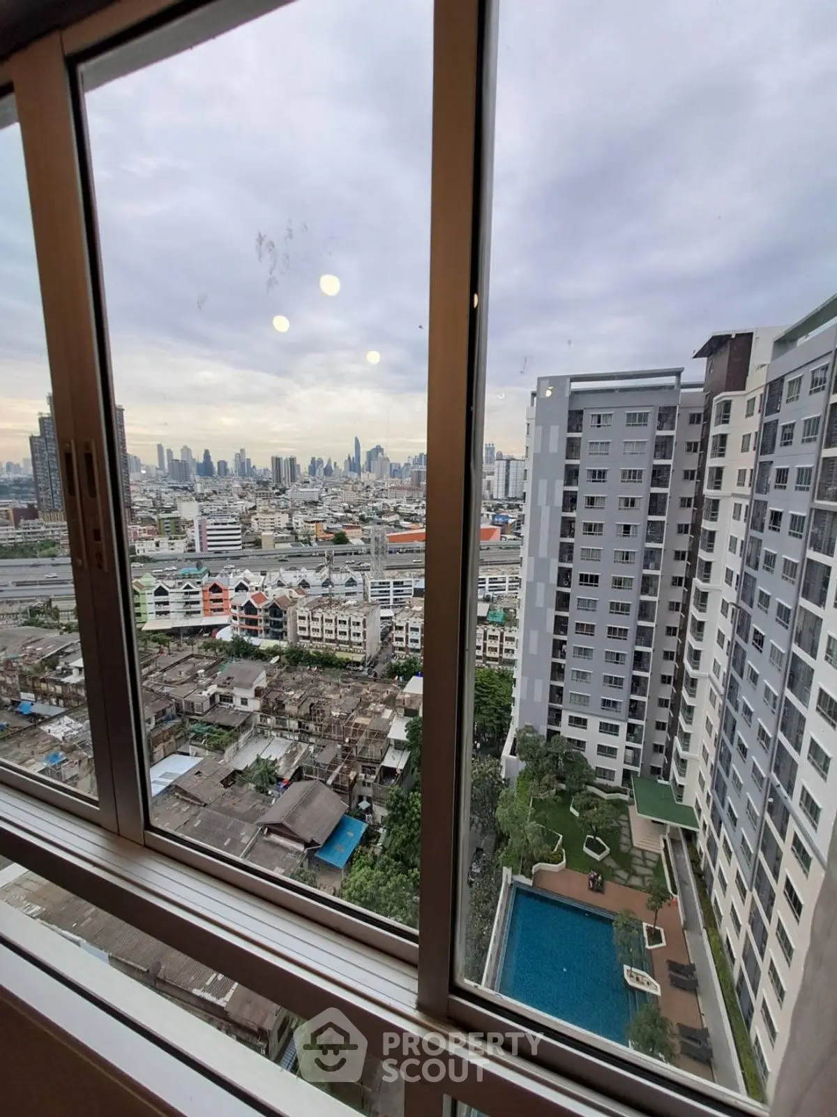 High-rise apartment with stunning city view and pool, ideal for urban living.