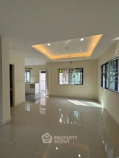 Spacious modern living room with glossy tiled floors and recessed lighting