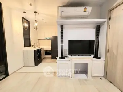 Modern living room with sleek TV setup and open kitchen layout