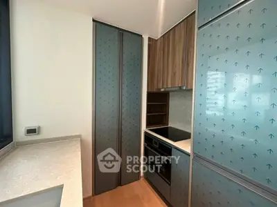 Modern kitchen with sleek cabinetry and built-in oven in contemporary apartment