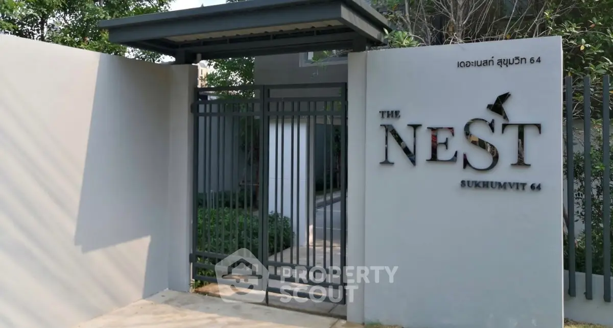 Modern entrance gate of The Nest Sukhumvit 64 with sleek design and greenery.