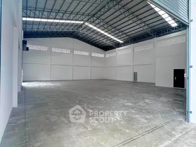 Spacious industrial warehouse with high ceilings and ample natural light.
