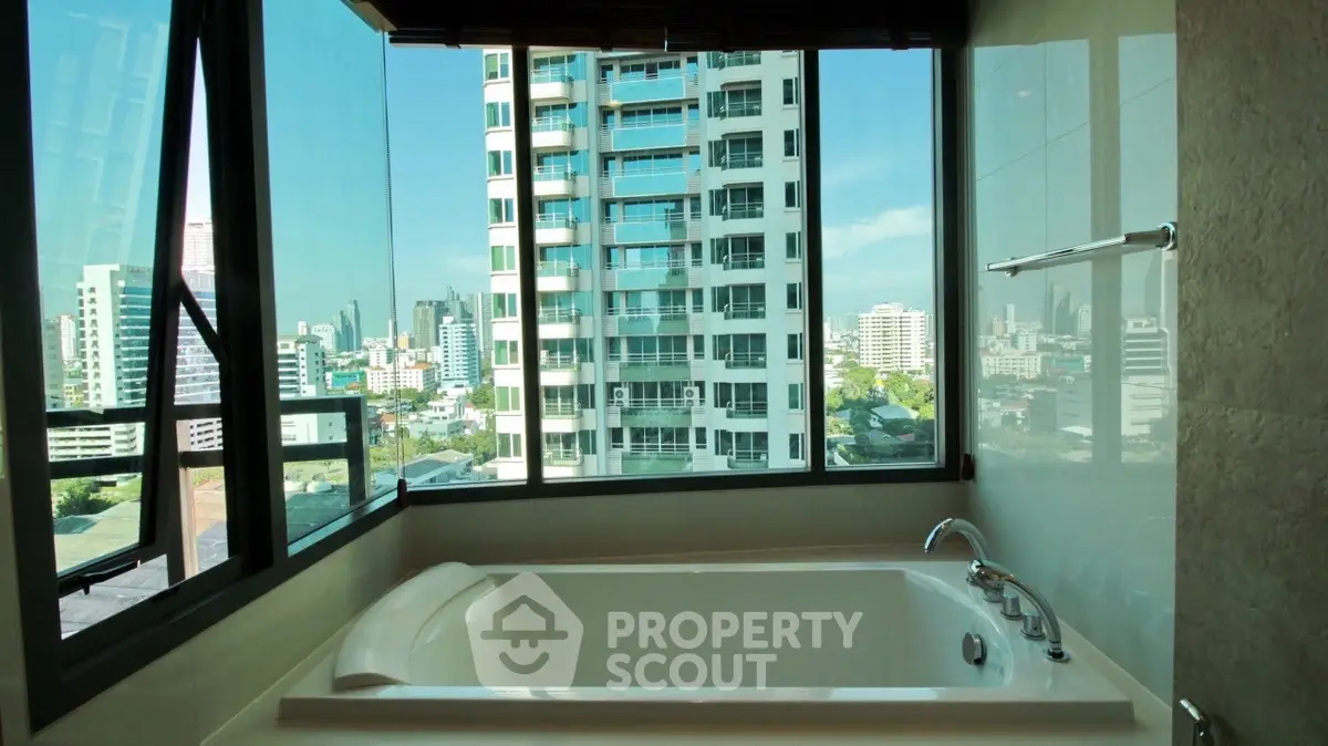 Luxurious bathroom with city view from large windows and modern bathtub.