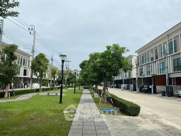 Modern townhouse complex with landscaped walkway and greenery
