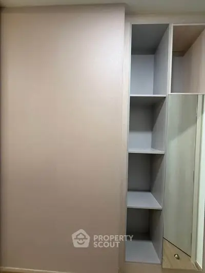 Modern built-in wardrobe with open shelving and mirror in a stylish bedroom.