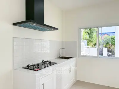 Modern kitchen with gas stove and sleek white cabinetry