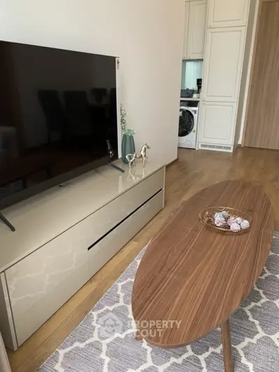 Modern living room with sleek TV stand and oval wooden coffee table
