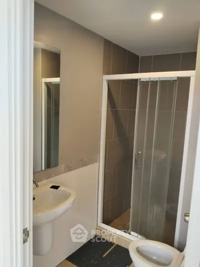 Modern bathroom with sleek shower and contemporary sink design.