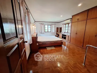Spacious bedroom with wooden flooring and built-in wardrobes