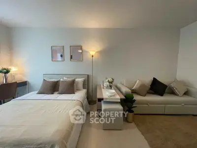 Cozy bedroom with stylish decor and comfortable seating area, perfect for relaxation.