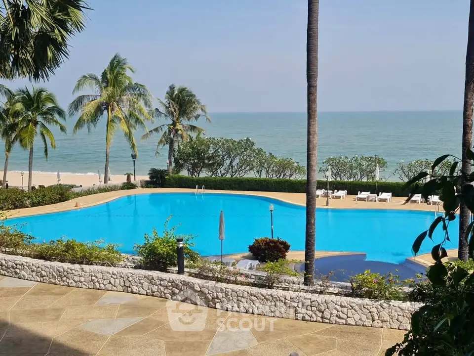 Stunning beachfront pool with ocean view and palm trees, perfect for luxury living.