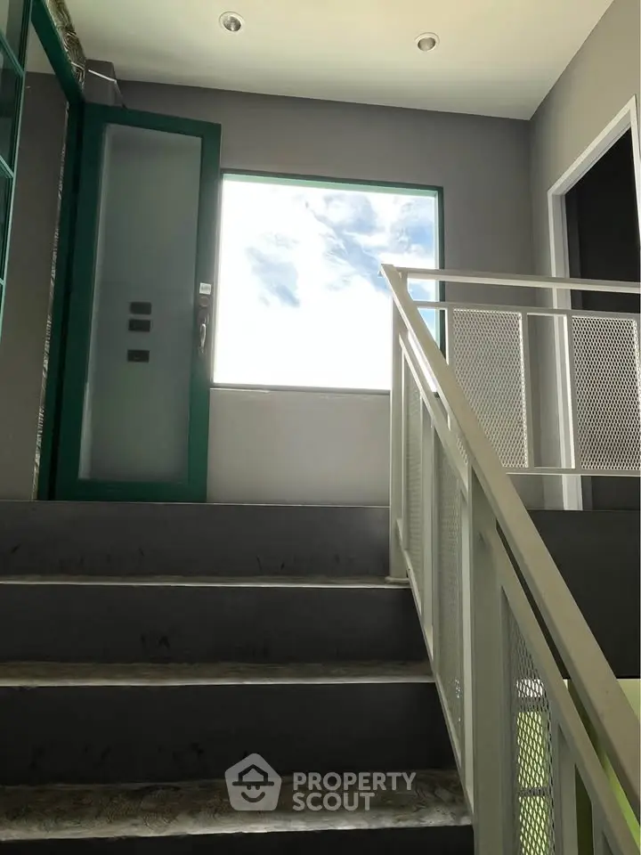 Modern stairway with large window and sleek railing design