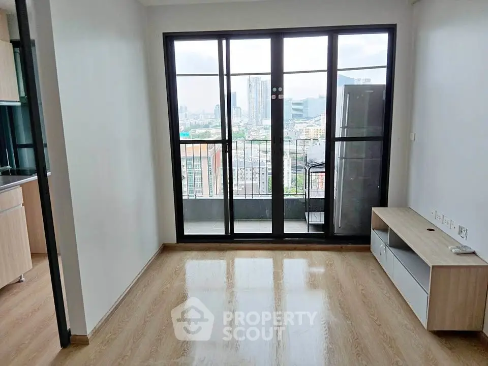 Modern living room with large windows and city view, featuring sleek wooden flooring and minimalistic design.