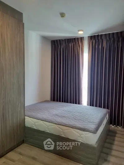 Cozy bedroom with modern design and ample natural light, featuring a comfortable bed and stylish curtains.