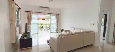 Spacious living room with modern sofa and large windows opening to a balcony.