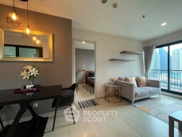 Modern living room with stylish decor and city view balcony in a high-rise apartment.
