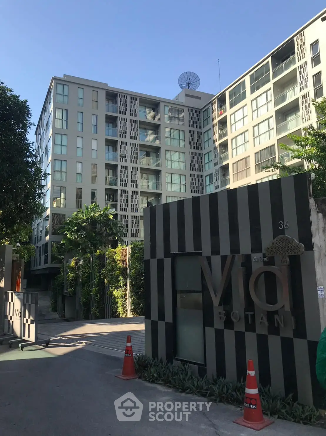 Modern condominium building with lush greenery and stylish entrance