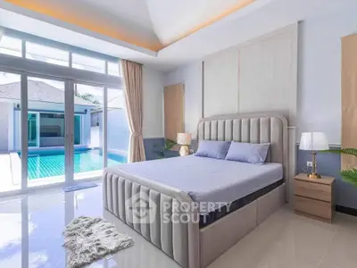 Luxurious bedroom with pool view, modern decor, and elegant furnishings in a serene setting.