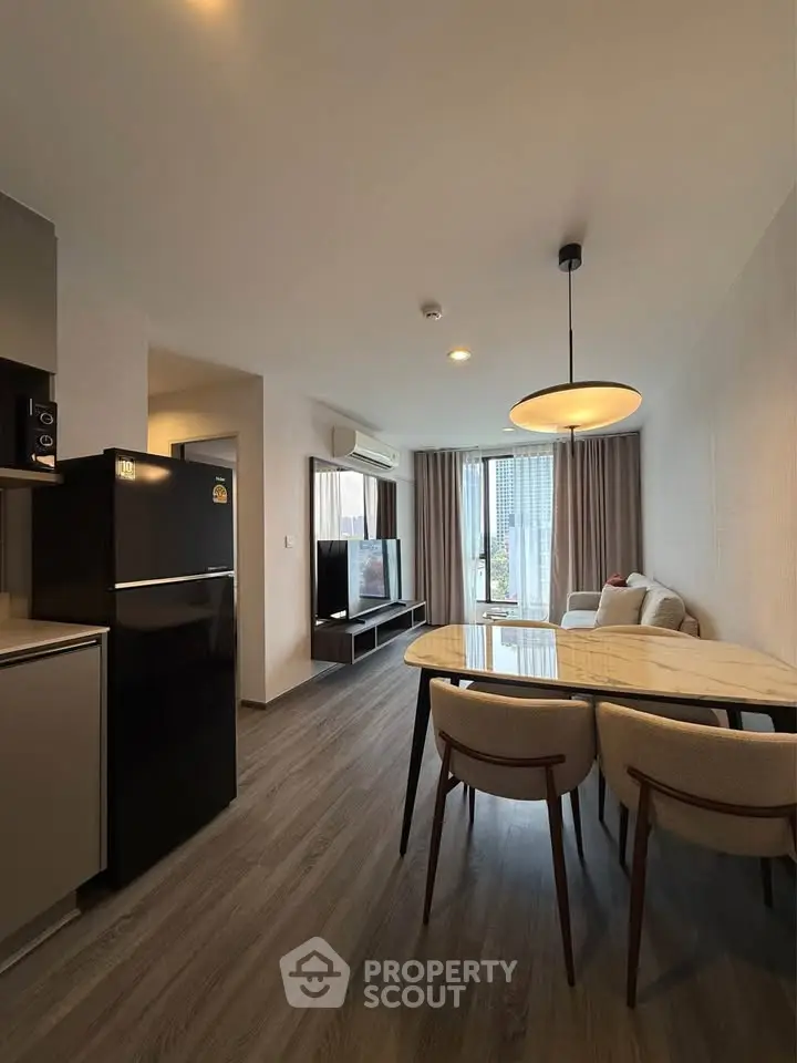 Modern living room with dining area and sleek furniture in a stylish apartment.