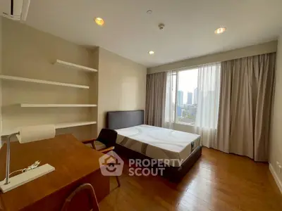 Spacious bedroom with city view, wooden flooring, and modern furnishings in a high-rise apartment.
