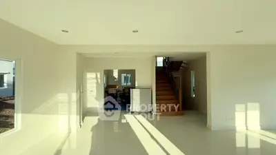 Spacious modern living room with staircase and large windows